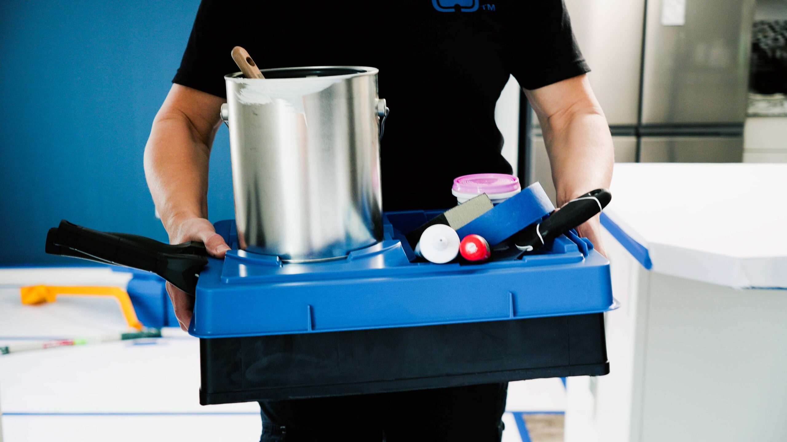 Karen Wolfe carries a paint tray with a blue PALOT Tray Pal lid and all of her painting supplies neatly collected on top.